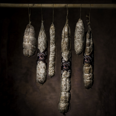 Assortiment Saucisson sec artisanal à l'ancienne sur une barre de bois